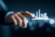 © sornram - A person interacts with a digital representation of a modern city skyline, showcasing innovation and technology in urban development.