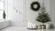 © AMIN - Minimalist christmas interior with small fir tree, white candles, and hanging ornaments in bright white room