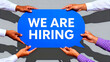 © NOVÁKOVÁ KATEŘINA - We are hiring sign held by diverse hands recruitment announcement job opening opportunity employment career growth team building business expansion staffing needs talent acquisition human resources co