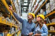 © Iftikhar alam - Two workers discuss inventory in a warehouse with shelves full of products during the day