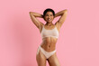 © Anastasiya - Closeup portrait of smiling young black woman in beige underwear on pink studio background. Fit toned body, natural confidence and healthy lifestyle expression