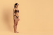 © Anastasiya - Side view pose of young black woman in brown underwear. Shows toned legs, sculpted glutes and smooth skin, perfect for weightloss, fitness progress, body sculpting and beauty care concepts