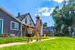 © unai - Mother and son walking on sidewalk in suburban neighborhood in drumheller, canada