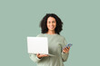 © Pixel-Shot - Young African-American woman with laptop and mobile phone on mint background