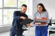 © Pixel-Shot - Stressed female worker with folders and her angry boss in office