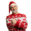 © opolja - Merry satisfied smiling mature man wear knitted christmas sweater Santa hat posing showing thumb up like gesture wink isolated on transparent background Happy New Year 2026 celebration holiday concept
