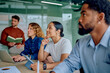 © we.bond.creations - Attentive diverse business professionals collaborating and learning in a modern office, focusing on an important presentation or discussion