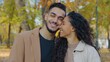 © Yuliia - Close-up happy hispanic couple smiling toothy hugging cuddling in autumn park closeness love bonding Arabian family hug cuddle in city outdoors smile looking away married man with woman autumnal fall