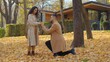 © Yuliia - Couple in autumn park man on one knee making marriage proposal to amazed woman in autumnal fall city happy guy giving ring to girlfriend married propose surprise girl answer yes agree hugging outdoor