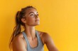 © Татьяна Евдокимова - Youthful woman with a ponytail feeling inspired, looking up with a thoughtful expression against a vibrant yellow background