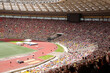 © Pavel Losevsky - A stadium full of people watching a race. The crowd is packed in the stands, and there are umbrellas being held by some of the spectators