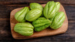 © Sabana - Fresh green chayote squash on a rustic wooden cutting board, healthy vegetable concept