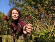© Pavel Losevsky - Woman is kneeling down in a field of flowers. She is holding a red flower in her hand