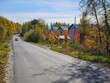 © Pavel Losevsky - Road with a car driving down it. The road is lined with houses. The houses are small and white