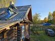 © Pavel Losevsky - Man is on the roof of a house. The roof is made of wood. A car is parked in the driveway