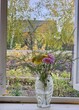 © Pavel Losevsky - Vase with flowers in it sits on a windowsill. The flowers are yellow and pink