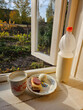 © Pavel Losevsky - Bottle of milk is on a table next to a plate of food. The food includes a sandwich on the window and an egg