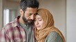 © evgenia_lo - A Middle Eastern man and woman in their early 30s embrace gently with their eyes closed. Soft light shines behind them as they reconnect in a domestic space
