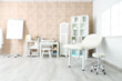 © Pixel-Shot - Blurred view of medical office with couch, doctor's workplace and shelf units