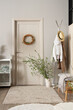 © Pixel-Shot - Door, clothes rack and vase with blossoming branches in stylish hall