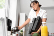 © Pixel-Shot - Busy young businesswoman pouring coffee from pot into cup while talking by phone in kitchen