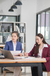 © Thitisak - Asian businesswoman at work using laptop talking and consulting in office
