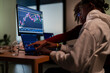 © Studio Marmellata - Two individuals collaborate, analyzing financial charts on multiple computer screens, indicating a focus on market trends and investment strategies.