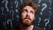 © backup_studio - Disoriented man with blue eyes and beard looking up, surrounded by question marks on a chalkboard. Concept of confusion, decision making, or seeking answer.
