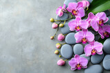 Natural arrangement of pink orchids on smooth gray stones for decoration or wellness purposes