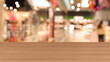 © New Africa - Empty wooden table against blurred view of shopping mall. Space for design