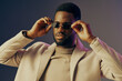 © SHOTPRIME STUDIO - Stylish African male model wearing sunglasses and a beige coat, exuding confidence against a soft gradient background, perfect for fashion and lifestyle themes