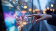 © Justlight - Medium shot of a hand engaging with a vibrant touchscreen digital signage highlighting interactive content against a blurred urban background for immersive user experience.