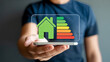 © HoneyStock - Person holding a smartphone displaying energy efficiency rating of a house