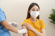 © Pormezz - People getting a vaccination to prevent pandemic concept. Woman in medical face mask receiving a dose of immunization coronavirus vaccine from a nurse at the medical center hospital