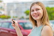 © luismolinero - Young blonde woman at outdoors holding car keys with happy expression