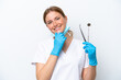 © luismolinero - Dentist caucasian woman holding tools isolated on white background happy and smiling