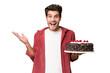 © luismolinero - Young caucasian man holding birthday cake over isolated background with shocked facial expression
