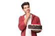 © luismolinero - Young caucasian man holding birthday cake over isolated background and looking up