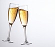 © theshooter - Dos copas de champán color dorado brindando en brindis de fin de año o celebración de fiesta o aniversario en fondo blanco liso  con espacio para texto y publicidad