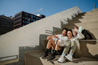 © Drobot Dean - Male and female athletes sitting on stairs and posing in front of the phone she is holding while smiling