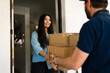 © AntonioDiaz - Happy woman receiving home delivery packages from a courier at her front door, expressing joy and satisfaction