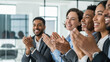 © Eve - Diverse business team clapping and celebrating success in a modern office meeting. Multi-ethnic professionals applauding achievement and excellent work.