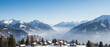 © Elenba - Stunning winter landscape with snow-covered mountains and charming wooden cabins nestled in valley. Scenic photo showcases tranquil winter scenery with majestic peaks and clear blue sky.