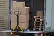 © ajcsm - Pallet jack in the back of a big van unloading pallets with boxes of products