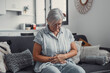 © Daniel - Elderly woman sits on a sofa at home holding her stomach, experiencing abdominal pain and discomfort. She looks tired and stressed while managing digestive issues during her daily life.