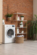 © Pixel-Shot - Interior of laundry room with washing machine, basket and shelf unit