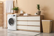 © Pixel-Shot - Interior of home laundry room with modern washing machine, dresser and basket