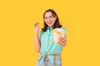 © Pixel-Shot - Beautiful young woman with french fries on yellow background