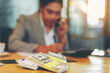 © Panumas - Cash money on the table with accountant woman working as blur background. Selected focus at money.