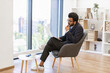 © sofiko14 - An Indian businessman is deep in thought while working on his laptop in a modern office setting